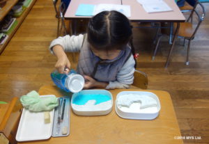 紙粘土で作った対照地形に色水を流し込む子