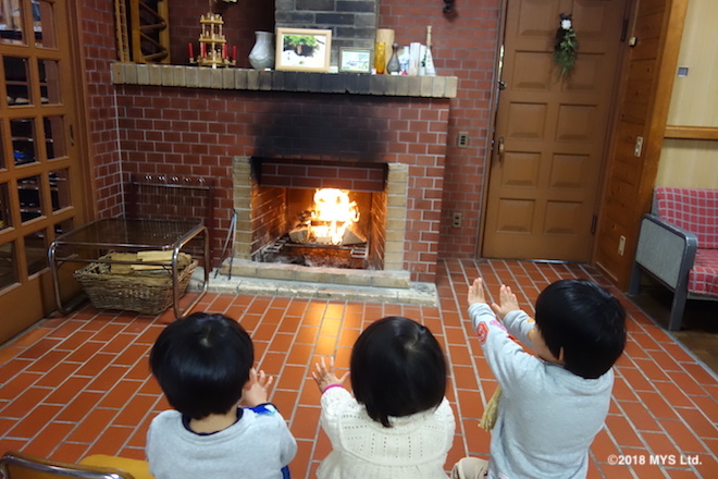 玄関の暖炉で暖まる子たち
