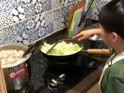 モンテッソーリ小学校で野菜を炒める子ども