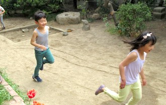 バンビーニの庭を駆け回る男女の幼児
