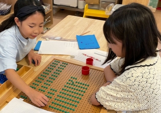 エレメンタリー教具を使って算数を学ぶ小学生